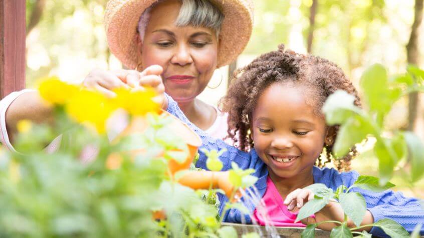 grandmother and grandchild watering their garden